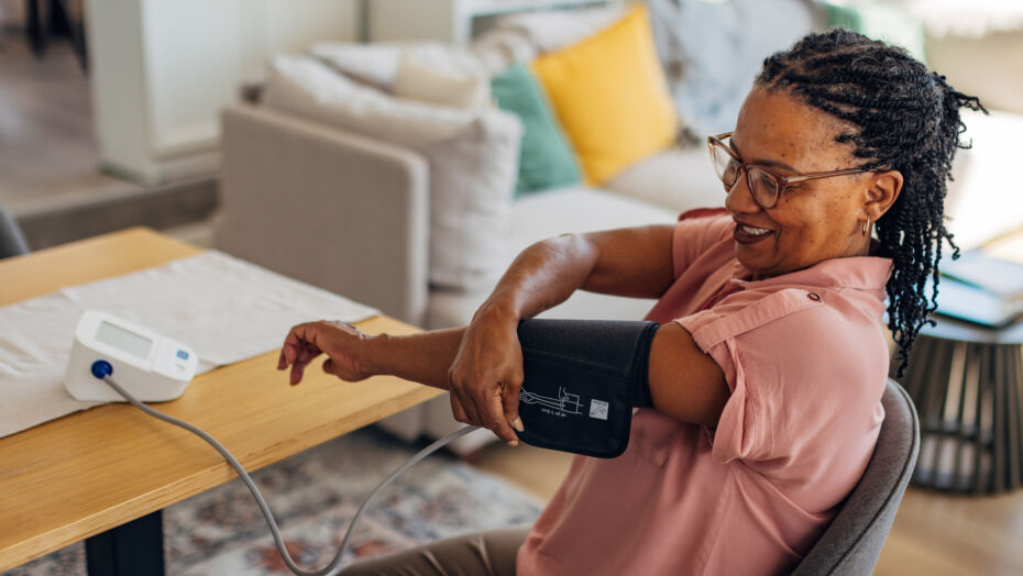 Mature woman taking her blood pressure at home