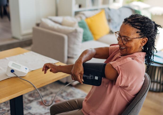 Mature woman taking her blood pressure at home