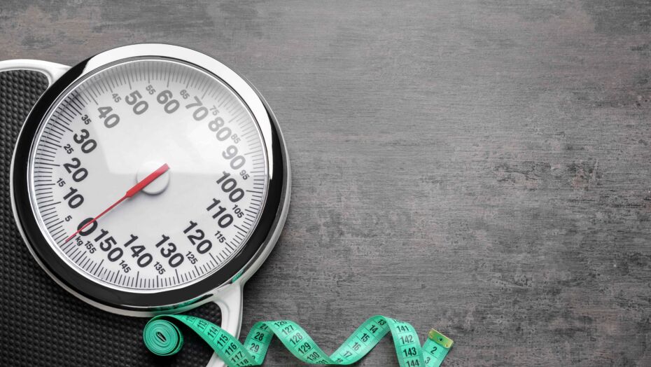 Scale with measuring tape strewn on floor