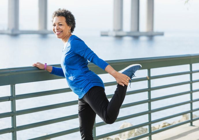 Older woman stretching outside