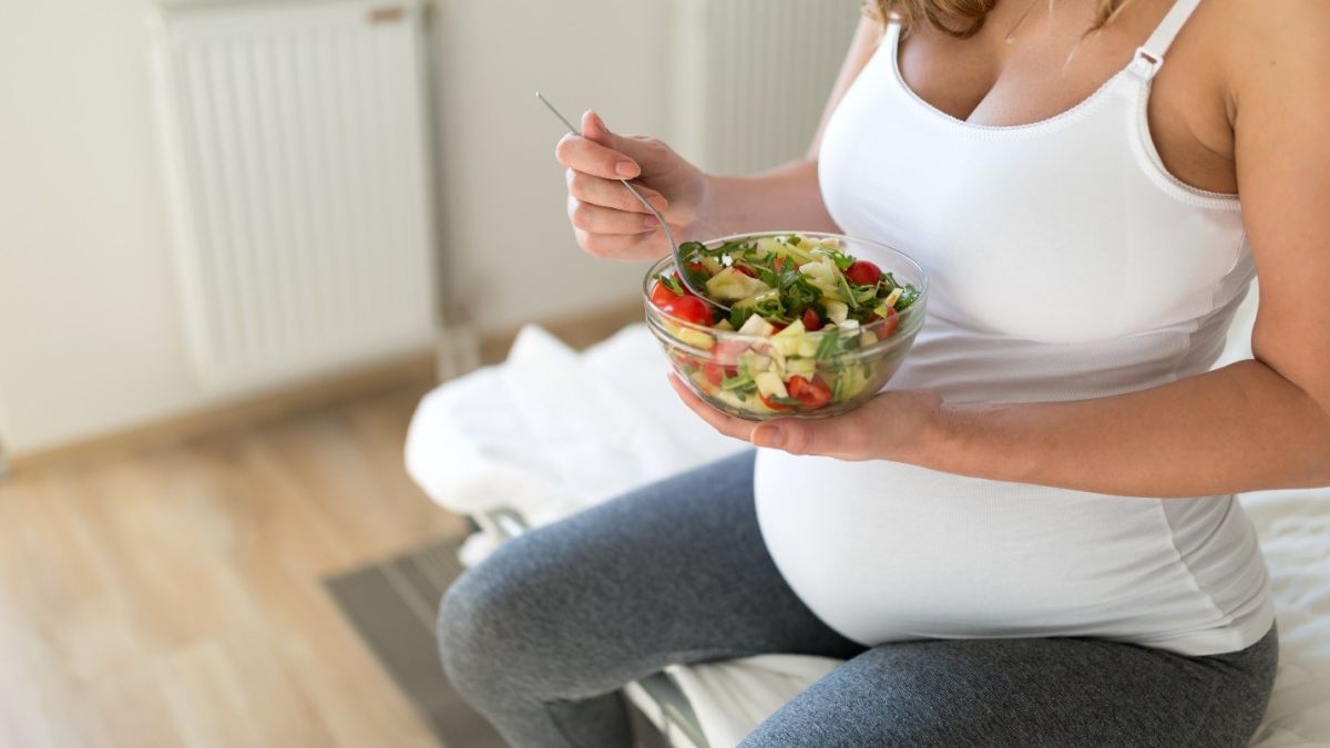 Pregnant mom eating a well-balanced salad