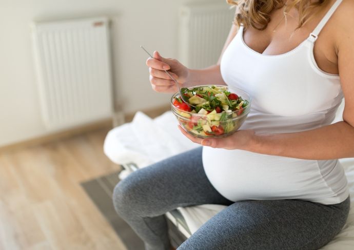 Pregnant mom eating a well-balanced salad