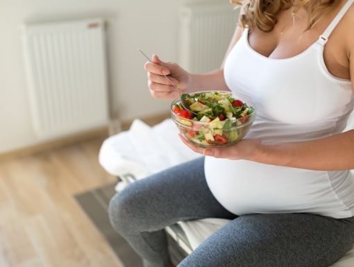 Pregnant mom eating a well-balanced salad