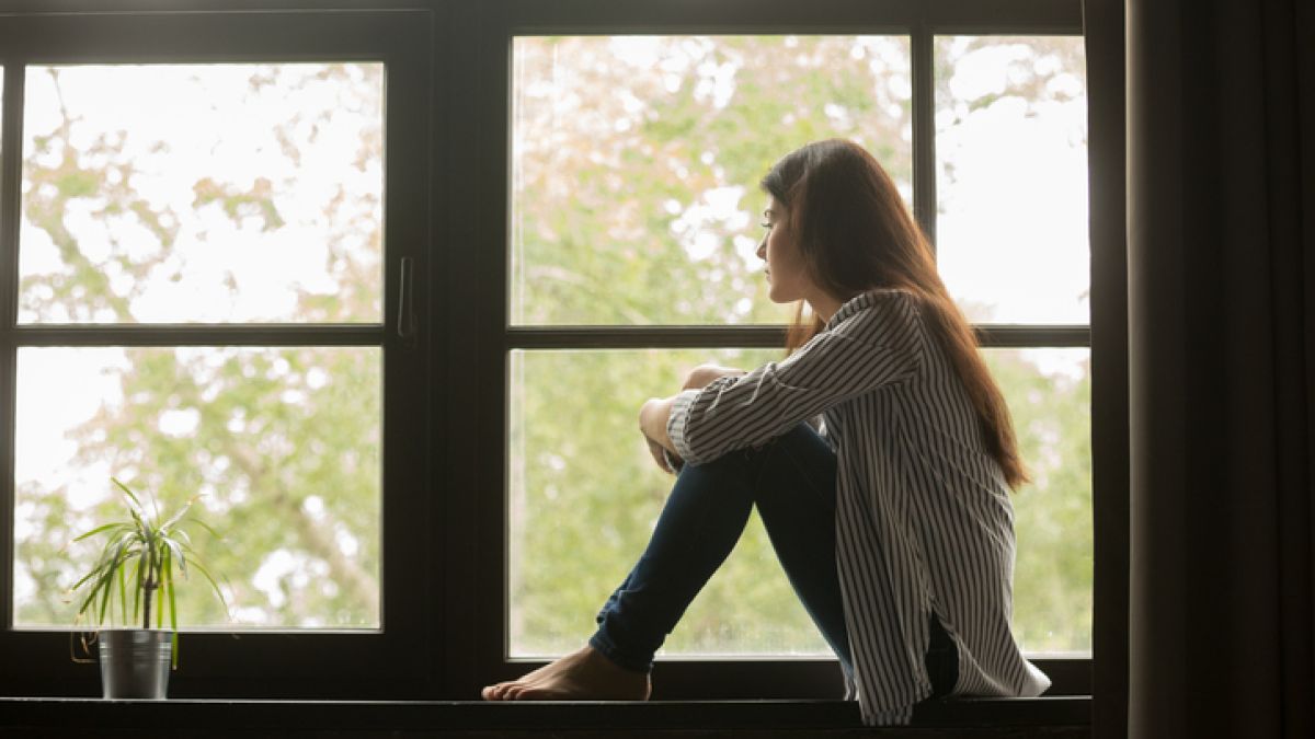 depressed woman looking out window