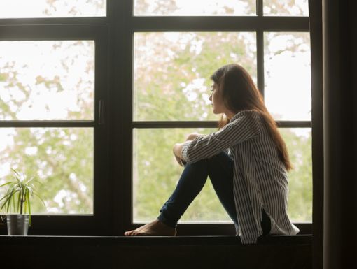 depressed woman looking out window