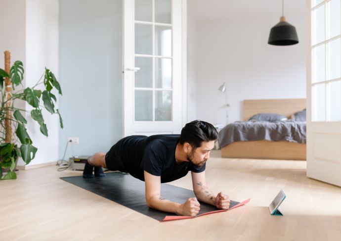 Man lying on floor using a fitness app