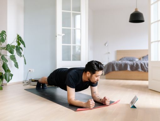 Man lying on floor using a fitness app