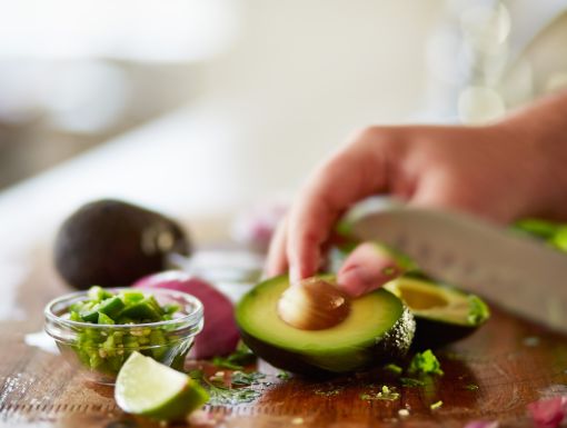 Man cutting avocado on cutting board