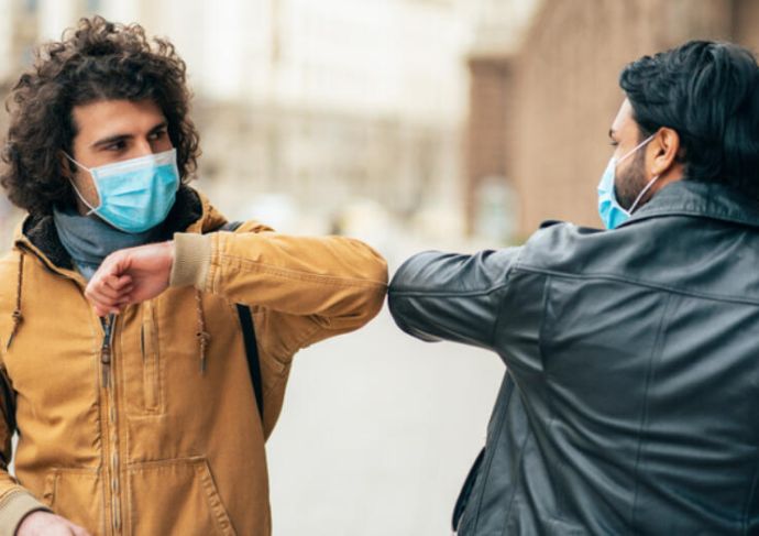 Guys bumping elbows with masks on