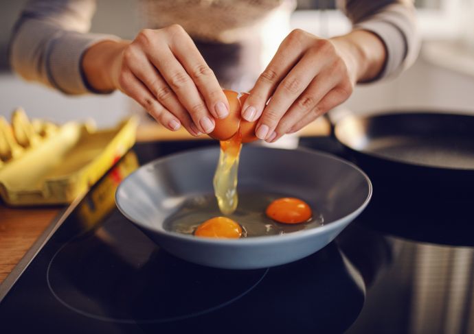 Close up of woman cooking eggs