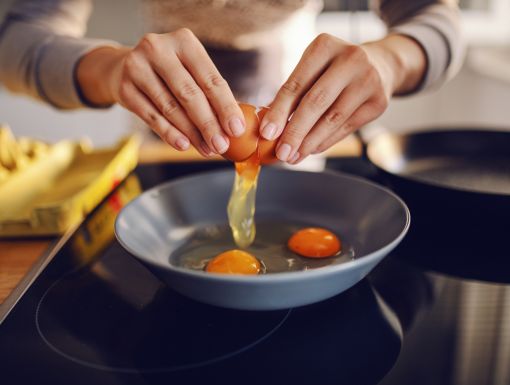 Close up of woman cooking eggs