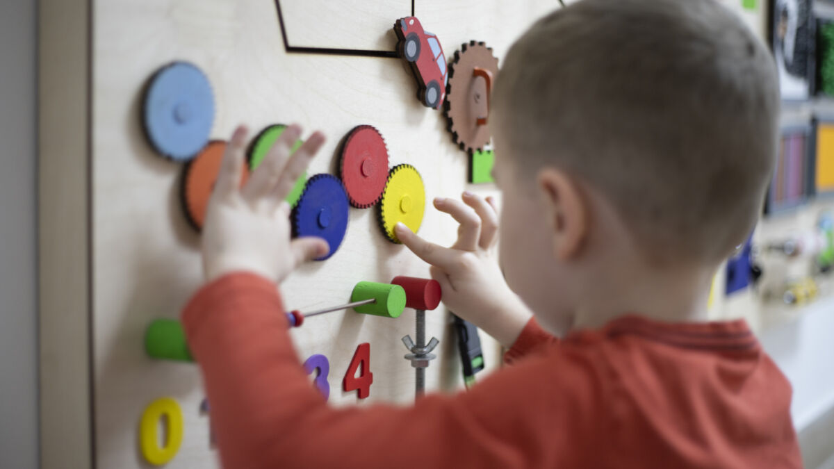 Boy playing with puzzle on wall