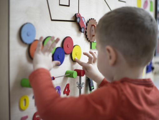 Boy playing with puzzle on wall