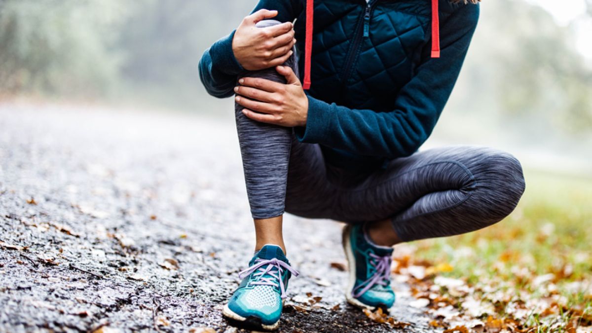 woman holding knee due to arthritis pain