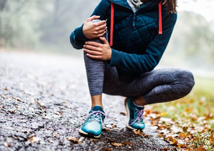 woman holding knee due to arthritis pain