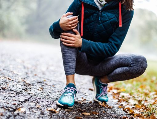 woman holding knee due to arthritis pain