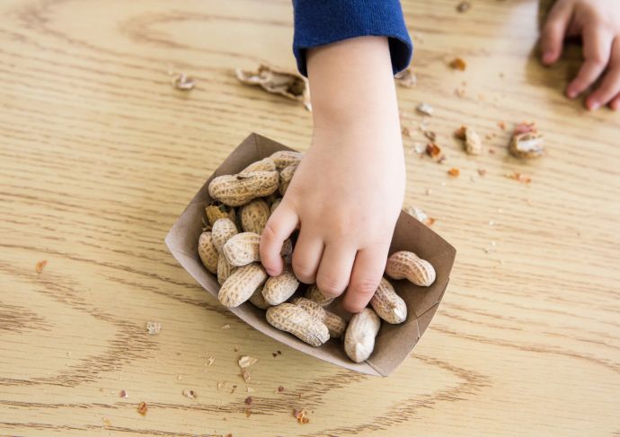 Child reaching for peanuts