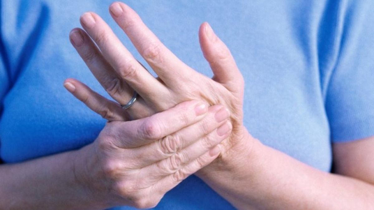 Woman rubbing palm due to pain caused by trigger finger