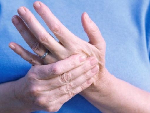 Woman rubbing palm due to pain caused by trigger finger