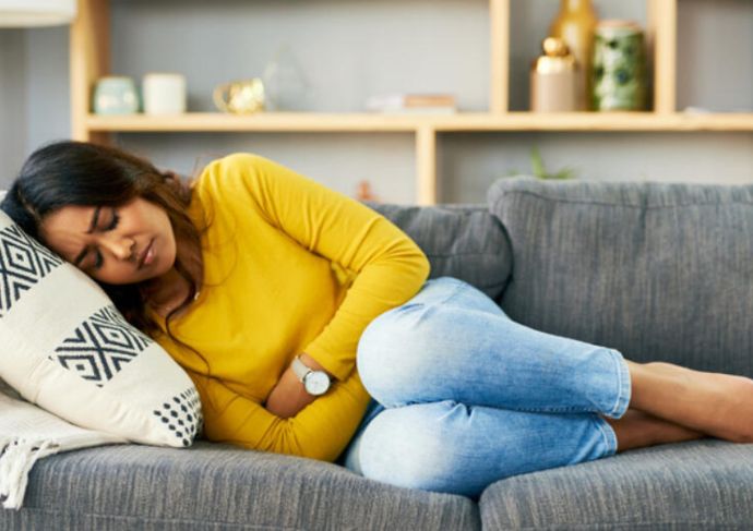 Woman laying on couch holding her stomach