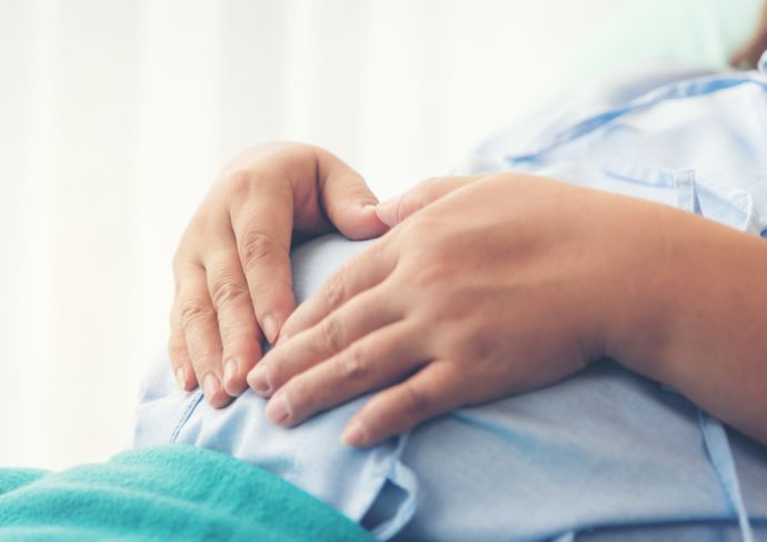 Woman with a heart on her pregnant belly