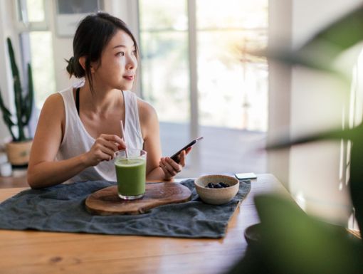 young woman with IBS having green drink