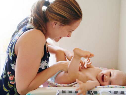 Mom changing baby diaper