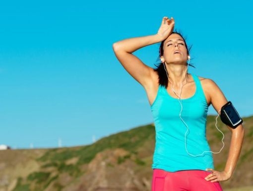 woman out jogging and sweating in the summer heat