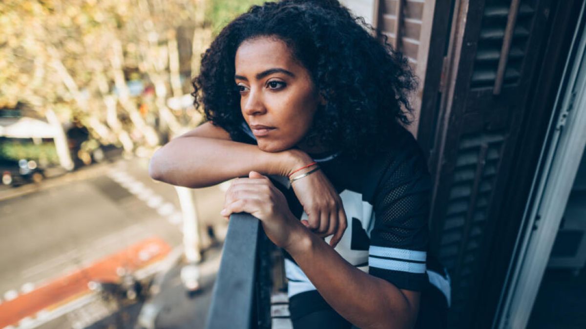 Woman with a headache looking outside her window