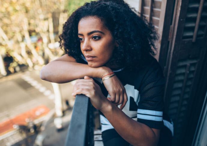 Woman with a headache looking outside her window