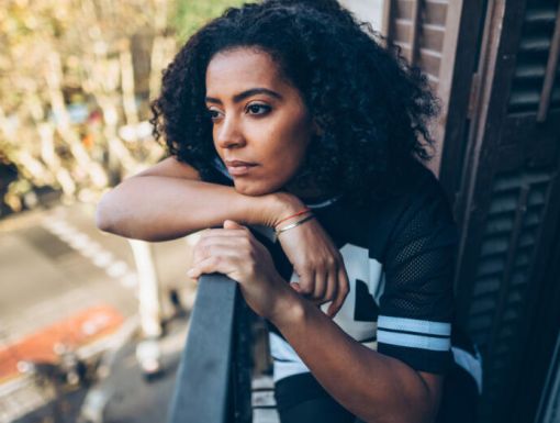 Woman with a headache looking outside her window