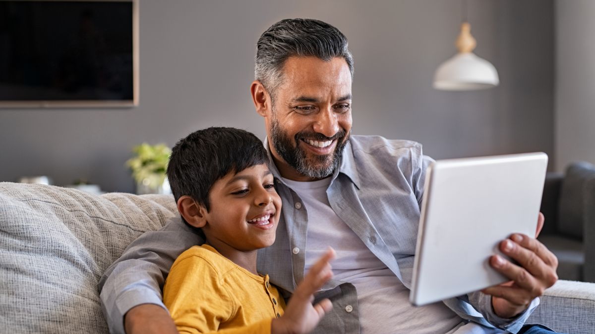 Father and son using digital tablet to make a video call