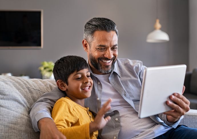 Father and son using digital tablet to make a video call