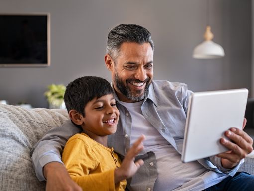 Father and son using digital tablet to make a video call