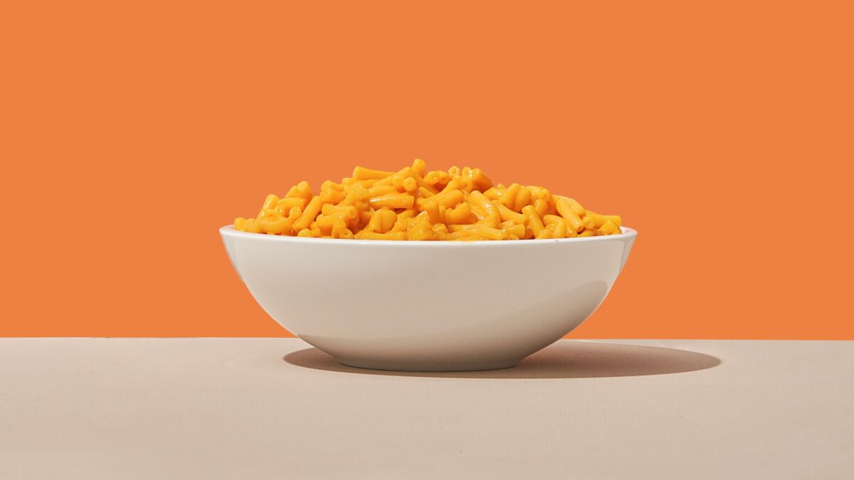 A bowl of boxed mac and cheese with an orange backdrop