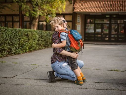Schoolboy hugging mom small