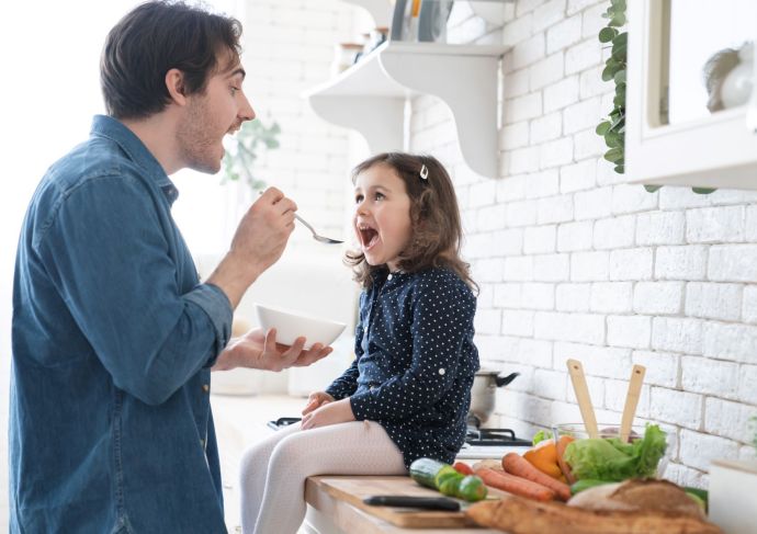 Dad feeding daughter