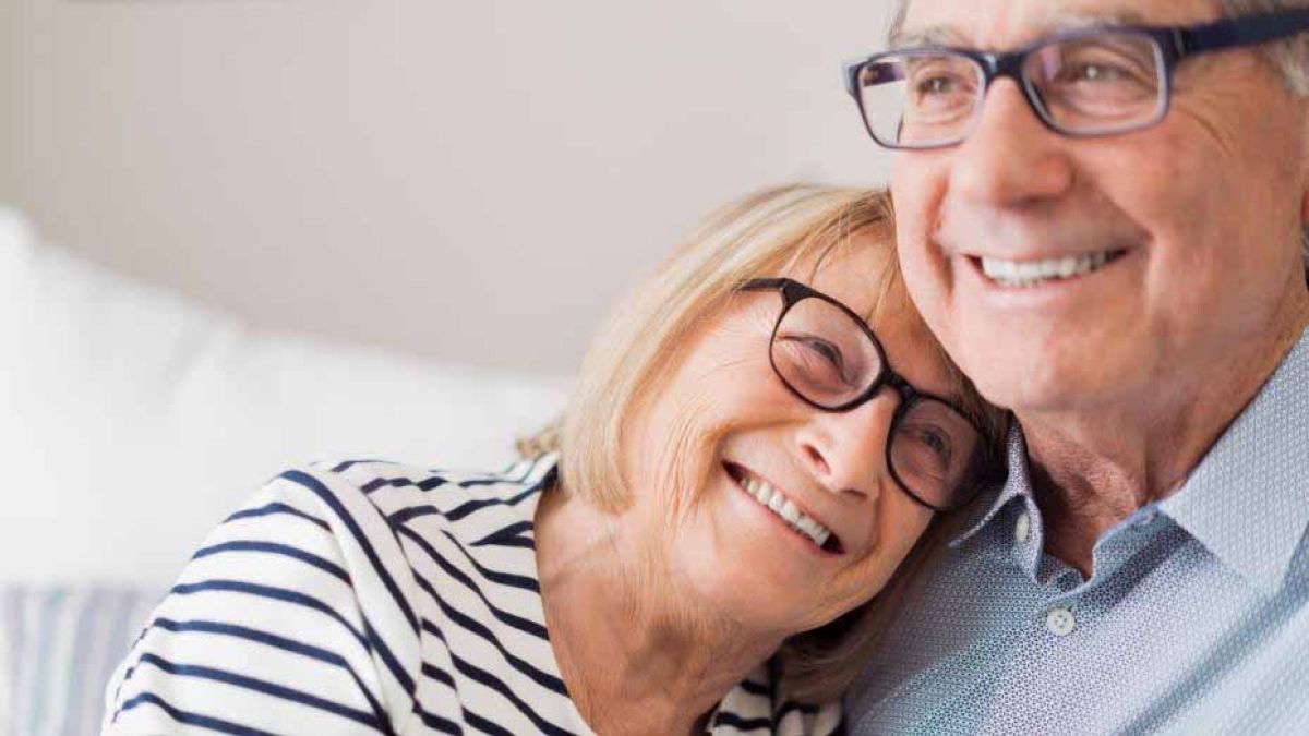 older man and woman hugging on couch