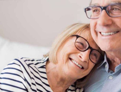 older man and woman hugging on couch