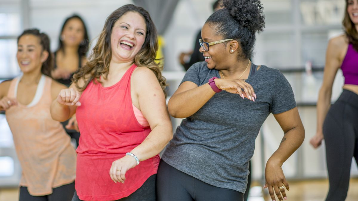 Two older women dancing together at a workout class