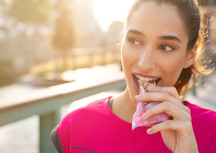 Woman eating a better protein bar option