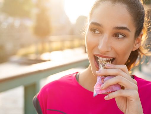 Woman eating a better protein bar option