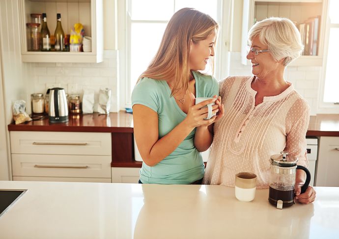 Mother and Daughter Drinking Coffee in the Kitchen