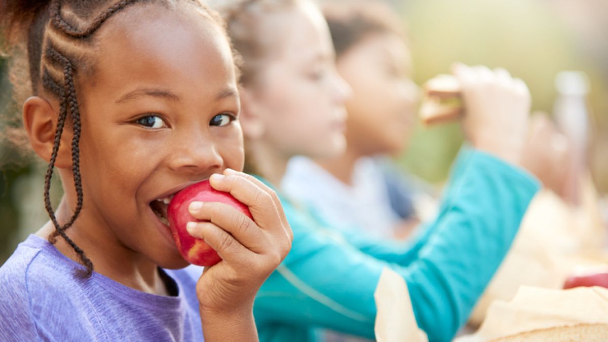 Young girl with IBD eating apple