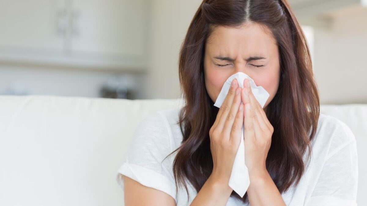 woman with flu blowing nose