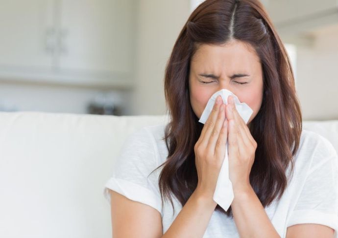 woman with flu blowing nose