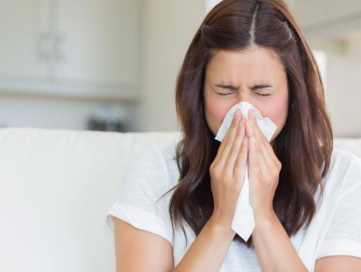 woman with flu blowing nose