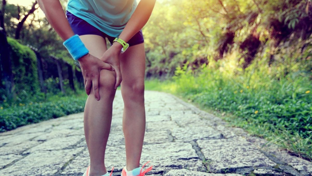 Woman Runner Holding Injured Knee