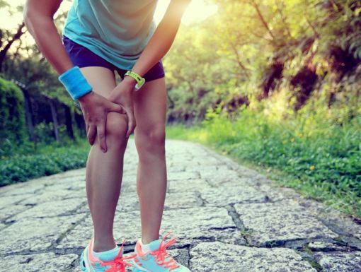 Woman Runner Holding Injured Knee