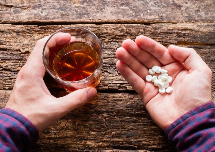 Man Holding A Glass Of Alcohol And Pills Scaled
